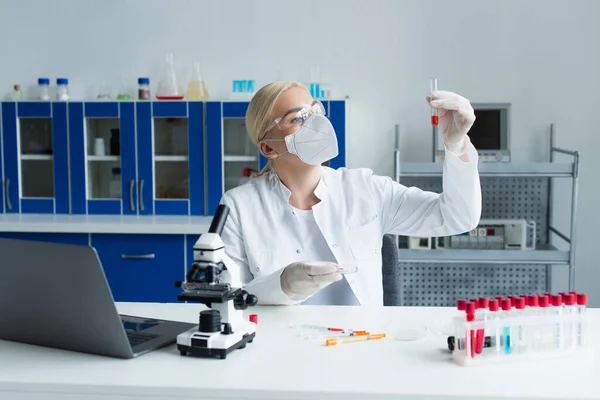 Scienziato in occhiali e guanti in lattice che lavora con provette e capsule di Petri in laboratorio — Foto stock