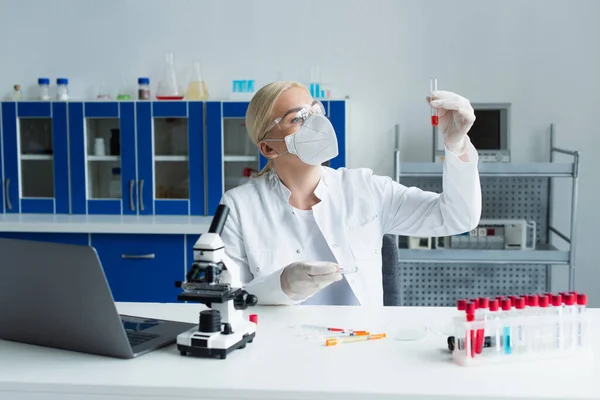 Scientist in goggles and latex gloves working with test tube and petri dishes in laboratory — Photo de stock