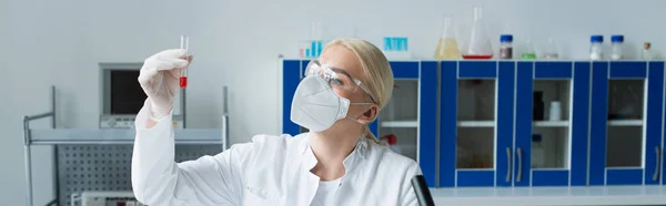 Scientist in protective mask holding test tube in laboratory, banner — Stock Photo