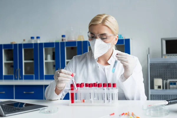 Cientista segurando tubos de ensaio com letras de antígeno e varíola em laboratório — Fotografia de Stock