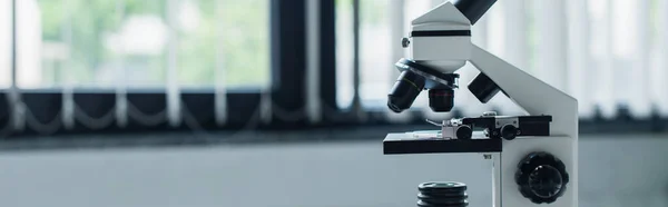 Microscope in blurred laboratory at background, banner — Fotografia de Stock