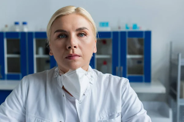 Scientist in protective mask looking at camera in laboratory — Stock Photo