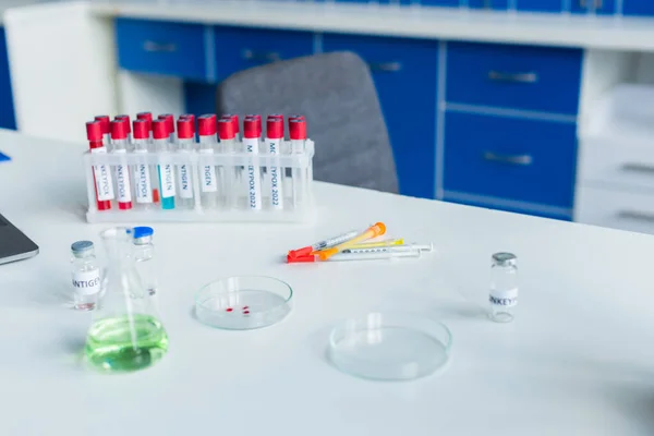 Vaccine and syringes near test tubes with monkeypox lettering in lab — Stock Photo