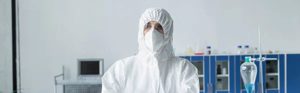 Cientista em traje protetor e máscara em pé no laboratório, banner — Fotografia de Stock