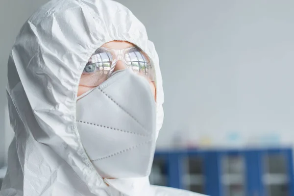 Ritratto di scienziato in tuta hazmat e maschera protettiva distogliendo lo sguardo in laboratorio — Foto stock