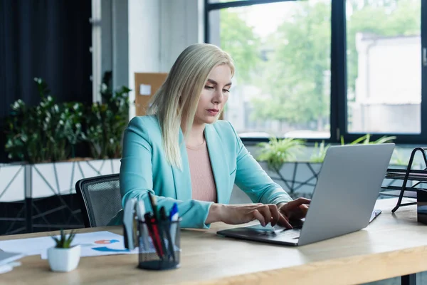 Psychologist using laptop near stationery in consultation room — Stockfoto