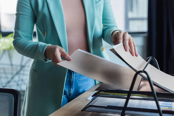 Cropped view of psychologist holding paper folder near documents in consultation room — Photo de stock