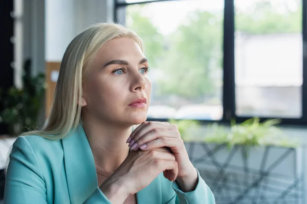 Thoughtful psychologist looking away in consultation room - foto de stock