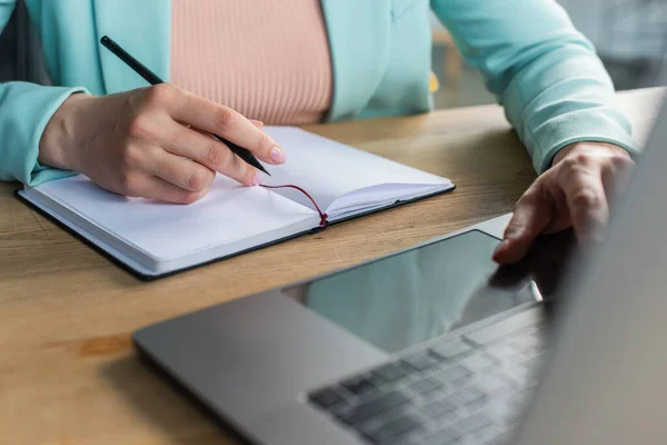 Vista ritagliata dello psicologo utilizzando laptop vicino al notebook nella sala di consultazione — Foto stock