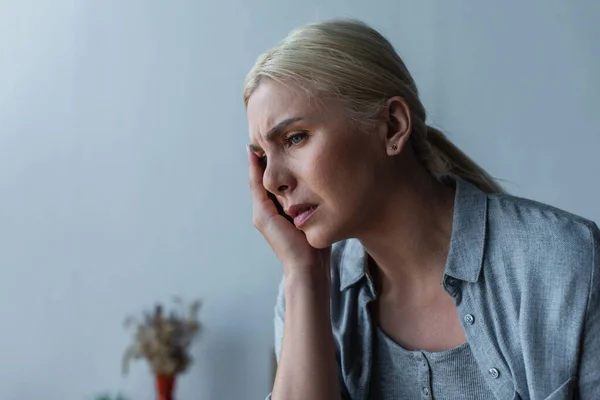 Esausta donna bionda con menopausa che soffre di mal di testa a casa — Foto stock