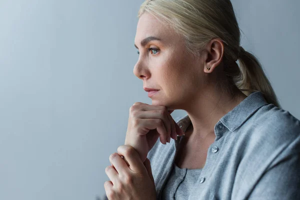 Portrait de femme blonde aux yeux bleus inquiet à cause de la ménopause — Photo de stock