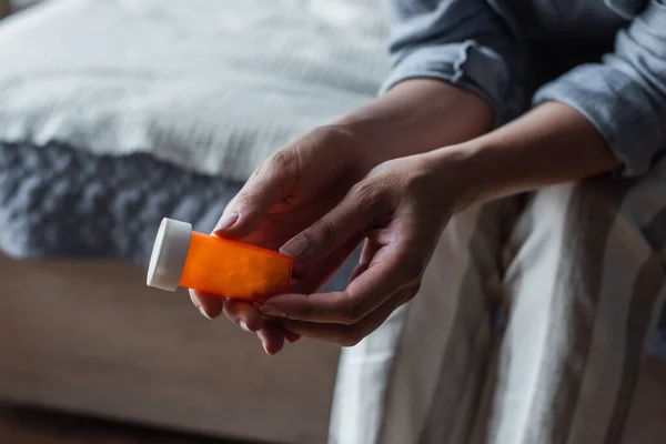 Cropped view of woman with menopause holding bottle with pills in hands — Stock Photo