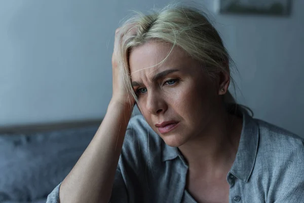 Mujer rubia agotada teniendo migraña durante la menopausia - foto de stock