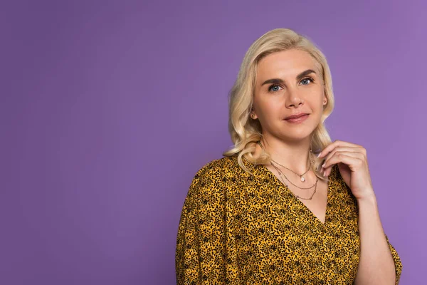 Portrait of joyful and blonde woman in blouse posing isolated on purple — Foto stock
