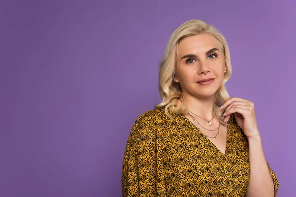 Portrait de femme joyeuse et blonde en chemisier posant isolé sur violet — Photo de stock