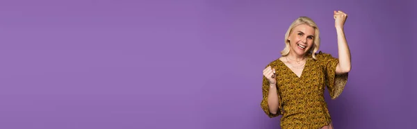 Felice donna bionda in camicetta con menopausa e gioia sul viola, striscione — Foto stock
