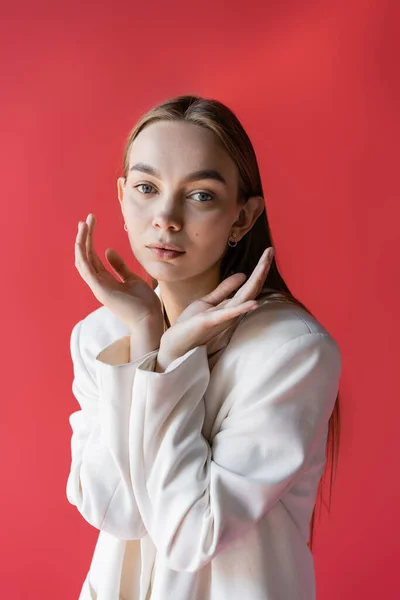 Sensuale giovane donna posa con le mani vicino al viso e guardando la fotocamera isolata su rosa — Foto stock