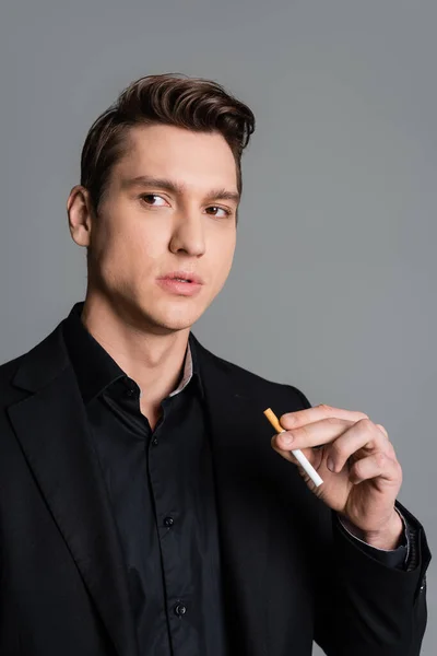 Serious man with cigarette looking away isolated on grey — Stock Photo