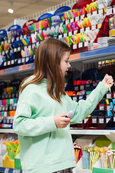 Girl choosing school supplies in stationery store — Stock Photo