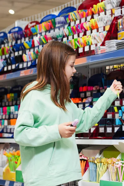 Mädchen wählt Schulbedarf im Schreibwarengeschäft — Stockfoto