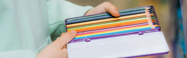 Cropped view of girl holding set of color pencils, banner — Foto stock