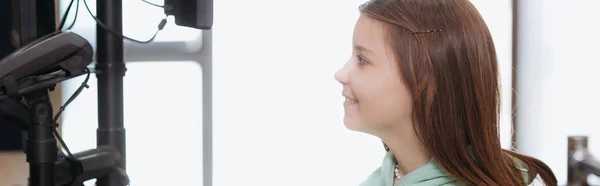 Side view of smiling girl looking at payment terminal in shop, banner — Photo de stock