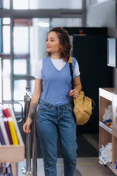 Glücklich tätowierte Studentin mit Rucksack betritt Schreibwarengeschäft — Stockfoto