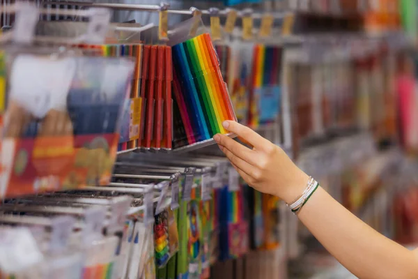 Vista cortada da mulher em pulseiras frisadas escolhendo pacote de canetas de feltro coloridas na loja de artigos de papelaria — Fotografia de Stock