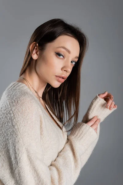 Charming woman in warm sweater looking at camera isolated on grey — Fotografia de Stock