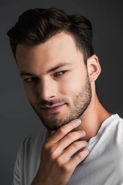 Portrait of brunette man holding hand near chin isolated on grey — Photo de stock