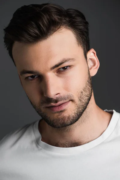 Portrait of young bearded man looking at camera isolated on grey — Fotografia de Stock