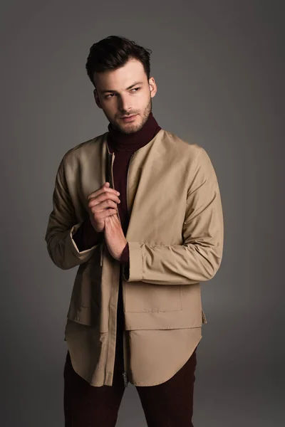 Trendy man in autumn outfit looking away isolated on grey — Photo de stock