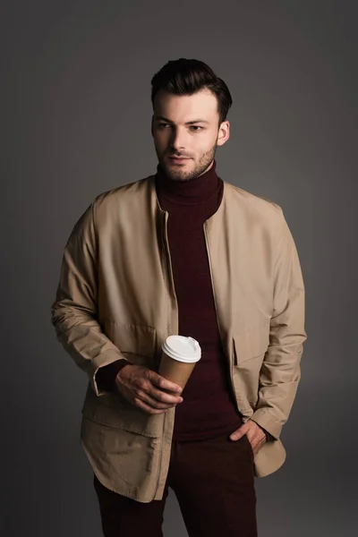 Stylish man in autumn outfit holding coffee to go isolated on grey — Stockfoto