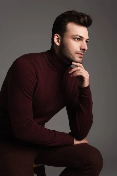 Young man in turtleneck looking away isolated on grey — Stockfoto