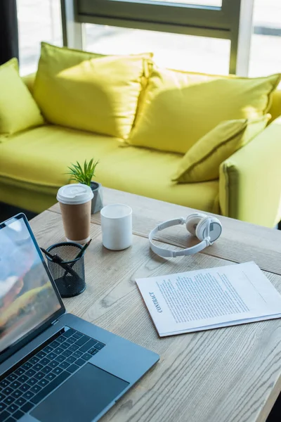 Contract near laptop and coffee to go on table in office - foto de stock