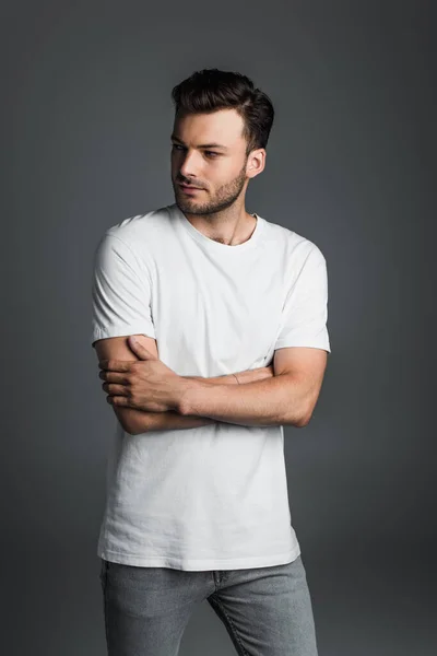 Young man in white t-shirt crossing arms isolated on grey — Foto stock