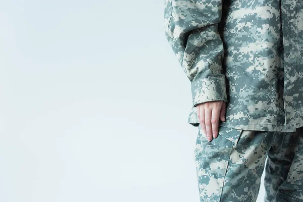 Cropped view of woman in military uniform standing isolated on grey — стоковое фото