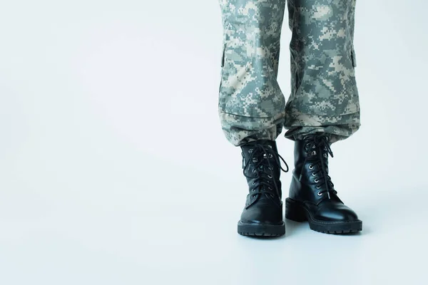 Cropped view of soldier in boots standing on grey background — стоковое фото