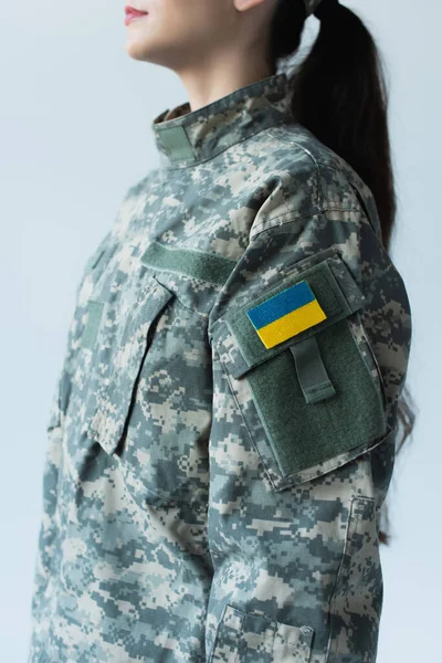 Розбитий вид на прапор українки на військовій формі військовослужбовця ізольований на сірому — стокове фото