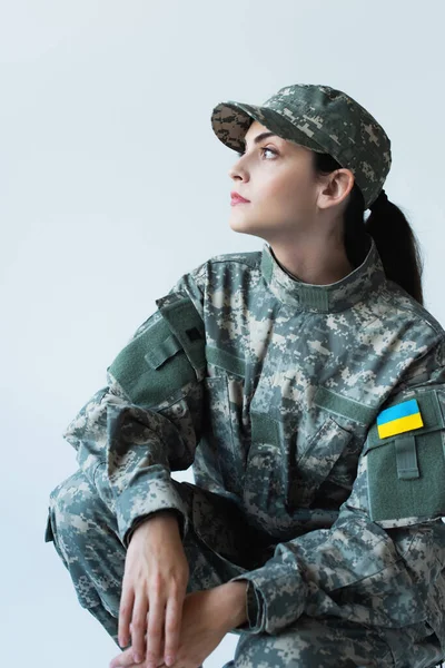Бічний вид служниці у формі з україніанським прапором на шевроні ізольований на сірому — стокове фото