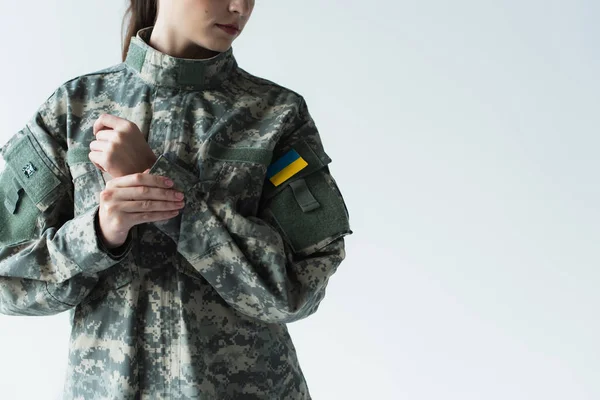 Cropped view of woman in military uniform with ukrainian flag isolated on grey — Stock Photo