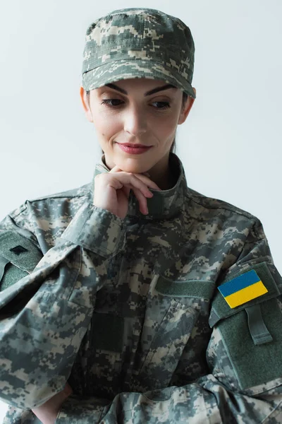 Portrait of pensive soldier in uniform with ukrainian flag isolated on grey — стоковое фото