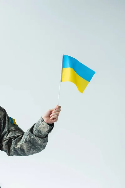 Розбитий вигляд солдата в уніформі з україніанським прапором, ізольованим на сірому — стокове фото
