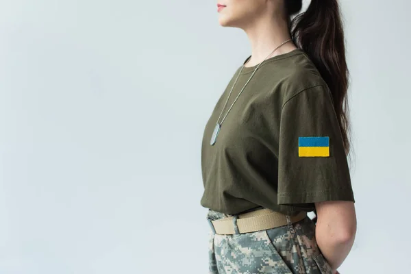 Cropped view of soldier with ukrainian flag on chevron standing isolated on grey — Stock Photo