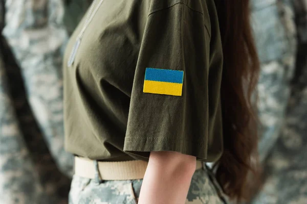 Розбитий вид на шеврон з україніанським прапором на уніформу солдата. — стокове фото