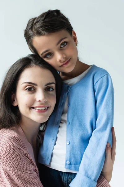 Happy woman and smiling child looking at camera isolated on grey — стоковое фото