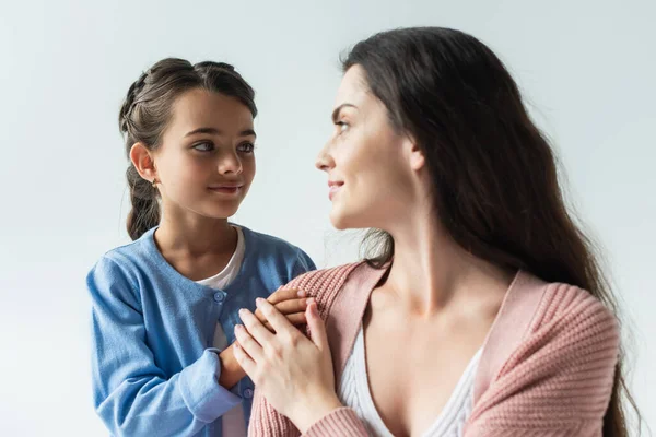 Girl touching shoulder of blurred mother isolated on grey — Stock Photo