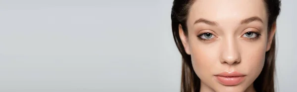 Close up view of young woman with blue eyes and makeup isolated on grey, banner — Stockfoto