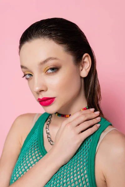 Young woman with bright makeup posing while looking at camera isolated on pink — Stockfoto