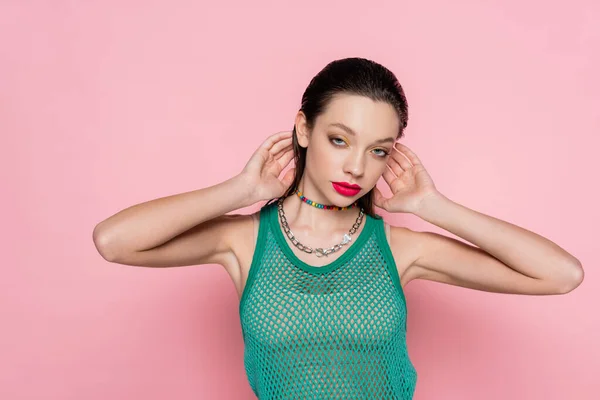 Young brunette woman with bright makeup posing and looking at camera isolated on pink — Foto stock